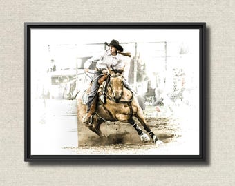 May include: Framed print of a rodeo scene. A rider in a cowboy hat and jeans on a horse is rounding a barrel. The horse is a light brown color, and the rider is wearing a white shirt. The background is a blurred image of a rodeo arena.