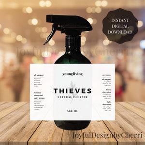May include: A white label with black text reads "youngliving THIEVES NATURAL CLEANER 500 ML". The label is attached to a green glass spray bottle. The label also includes dilution instructions for all-purpose, heavy degreasing, and light degreasing.