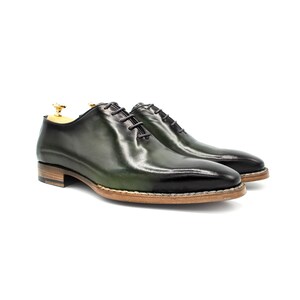 May include: A pair of green leather lace-up dress shoes with a brown sole.