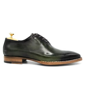 May include: Green leather lace-up dress shoes with a brown sole.