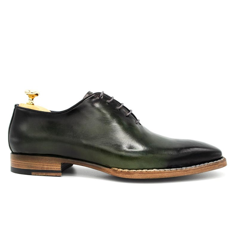 May include: Green leather lace-up dress shoes with a brown sole.