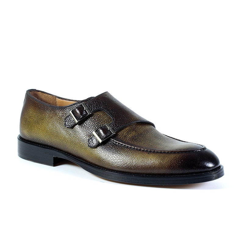 May include: A pair of brown leather double monk strap shoes with a textured finish.