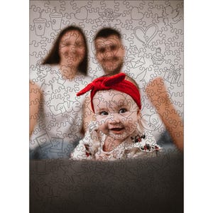 Może przedstawiać: Zbliżenie na małą dziewczynkę w czerwonej opasce i białej sukience. Dziewczynka uśmiecha się i patrzy w obiektyw. Rodzice dziewczynki są rozmyci w tle.