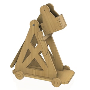 May include: A wooden model of a catapult with a brown finish. The catapult has a raised arm and a small wooden bucket at the end of the arm. The catapult is on wheels and has a simple design.