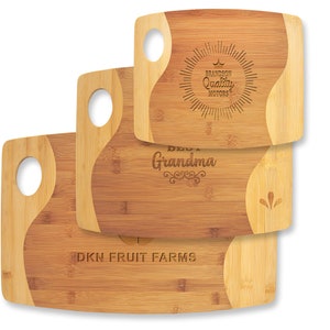 May include: Three wooden cutting boards with engraved text. The top board says "Brandon Quality Motors" with a crown and sunburst design. The middle board says "Best Grandma" with a decorative flourish. The bottom board says "DKN Fruit Farms".