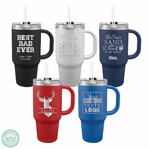 May include: A collection of insulated travel mugs in various colors, each with a handle, straw, and personalized text or graphics. The mugs include black, white, red, and blue options, with phrases like "Best Dad Ever" and "Sun, Sand, and a Drink in My Hand."