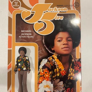 May include: A retro-style action figure of Michael Jackson in a floral shirt and brown pants, packaged in a brown and orange box. The packaging features the text "Jackson 5" and "Michael Jackson Action Figure". The box also has a warning label and an "Out of Stock" sticker.