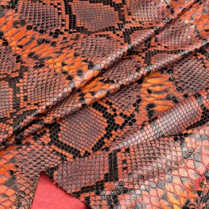 Orange läderhud med reptileffekt, präglat ormskinn, kostymtillverkning, läderhantverksrester, andrahandsexemplar