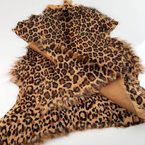 May include: A brown and black leopard print faux fur rug with a soft, fluffy texture.