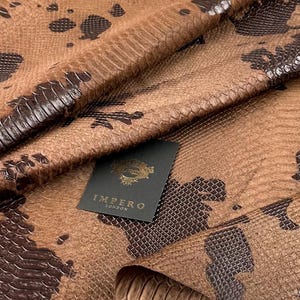 Unique hair-on calf hide with an exotic snakeskin-style print in brown and black tones, ideal for sneaker designers and luxury leather accessories