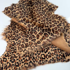 May include: A brown and black leopard print faux fur fabric with a shaggy texture.