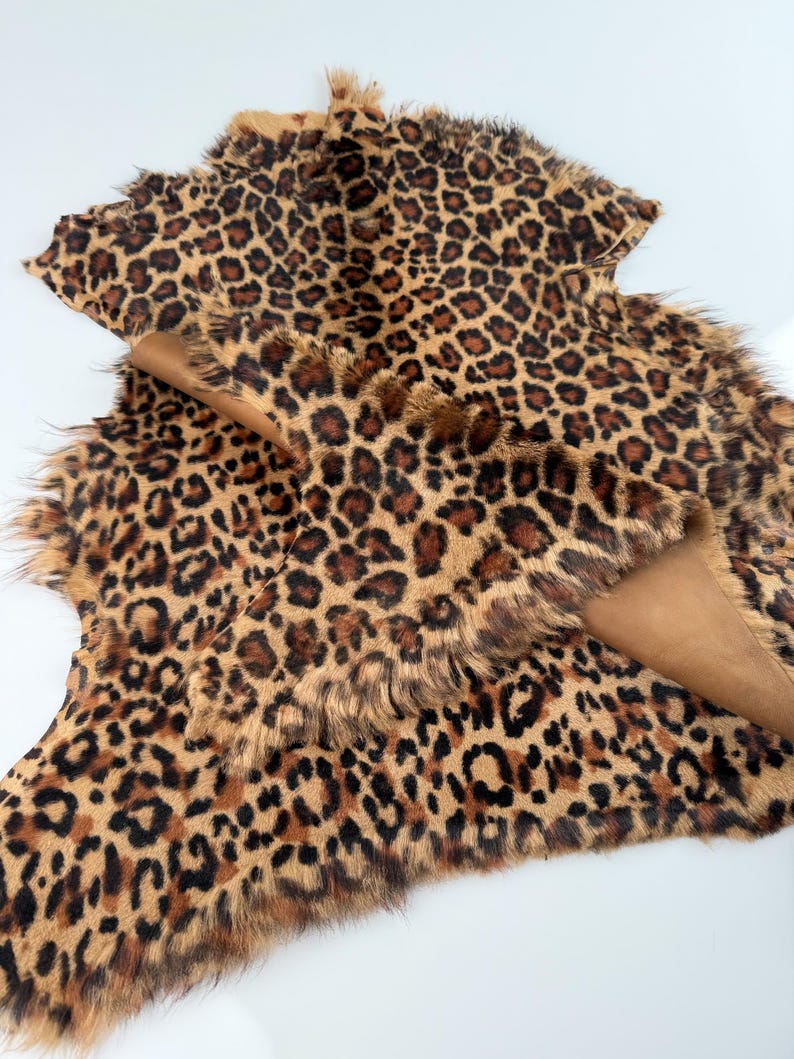 May include: A brown and black leopard print faux fur fabric with a shaggy texture.
