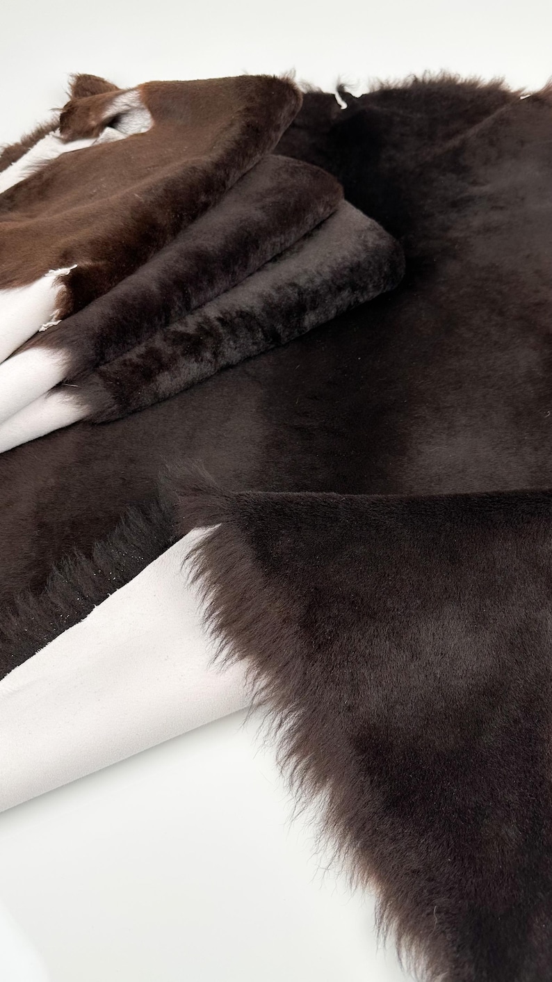 May include: A stack of brown faux fur fabric with a white backing. The fur is soft and fluffy.