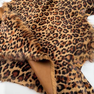 May include: A brown and black leopard print faux fur hide with a brown leather backing.