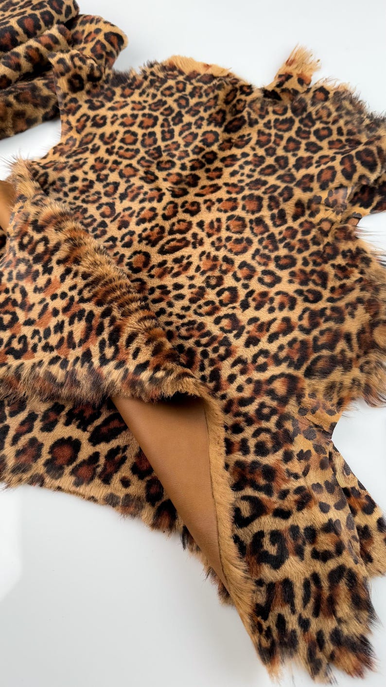 May include: A brown and black leopard print faux fur hide with a brown leather backing.