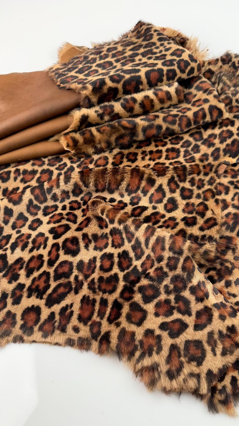 May include: A brown and black faux fur fabric with a leopard print pattern.