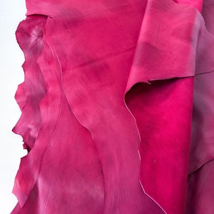 Pu&ograve; includere: Una pila di pelli di cuoio rosa. Il cuoio &egrave; morbido e flessibile, con una finitura liscia.