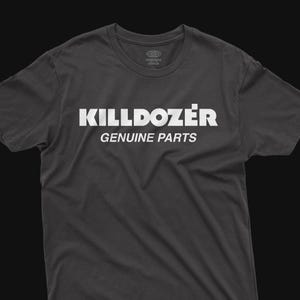 Może przedstawiać: Ciemnoszara koszulka z białym napisem "KILLDOZER" i poniżej "GENUINE PARTS". Koszulka ma również napis "midnight climax" u góry. Codzienna odzież.