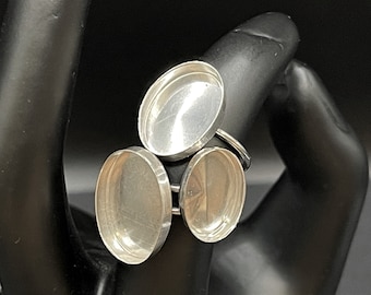Puede incluir: Anillo de plata con tres engastes redondos, vacíos, de plata.