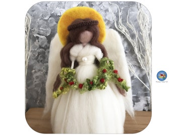 May include: A white felt angel with brown hair and a yellow halo, holding a green and red garland. The angel is wearing a white dress with a pearl accent.