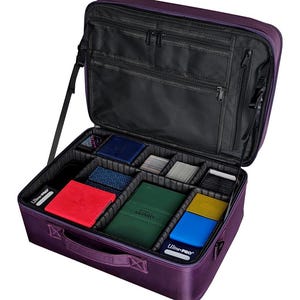 May include: A purple Ultra-Pro card carrying case, open to reveal multiple compartments. The case contains various colored card holders, including red, green, blue, and yellow, along with stacks of cards and other accessories.
