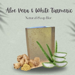 May include: A natural soap bar with a light yellow color, made with aloe vera and white turmeric. The soap bar is surrounded by pieces of aloe vera and turmeric root.