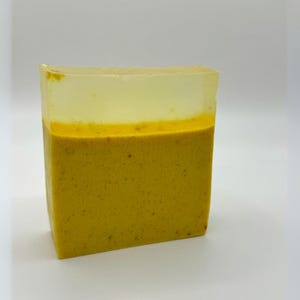 May include: A yellow bar of soap with a clear top layer. The soap has a rough texture.