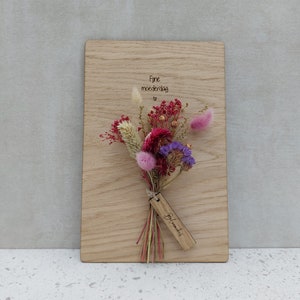 Tarjeta de madera de moda con flores secas.