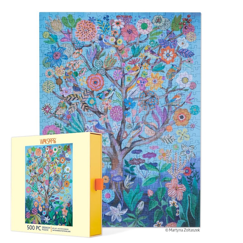 K&ouml;nnte beinhalten: Ein fertiges 500-teiliges Puzzle mit einem farbenfrohen Baum mit Blumen und V&ouml;geln vor einem hellblauen Hintergrund. Das Puzzle befindet sich neben seiner gelben Schachtel, die ebenfalls das Puzzle-Bild zeigt. Auf der Schachtel steht "WAKSPAP" und "500 PC".