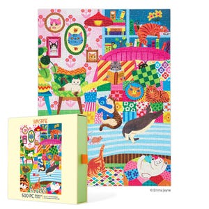 May include: A 500-piece jigsaw puzzle featuring a colorful illustration of cats in a whimsical interior setting. The puzzle includes various cat portraits, furniture, and decorative elements. The puzzle box is visible, showing the completed puzzle image.