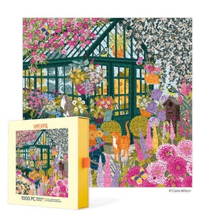 May include: A 1000-piece jigsaw puzzle featuring a colorful garden scene with a greenhouse, flowers, cats, and butterflies. The puzzle box is yellow and displays the puzzle image. The puzzle measures 24 x 30 inches when completed.