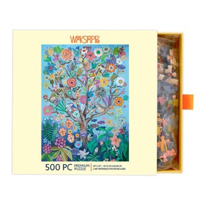 K&ouml;nnte beinhalten: Ein 500-teiliges Puzzle in einer gelben Box mit einem farbenfrohen Baumdesign mit Blumen und V&ouml;geln. Die Box zeigt den Text "WAKSIAPP" und "PREMIUM PUZZLE". Das Puzzle misst 45,72 cm x 60,96 cm.