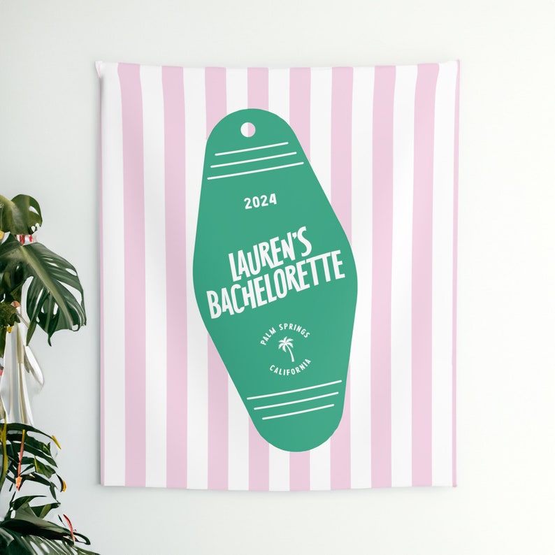 May include: A green motel key tag with white text that says "2024 Lauren's Bachelorette Palm Springs California" on a pink and white striped background.