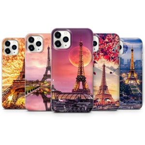 Puede incluir: Cinco fundas de teléfono diferentes con la Torre Eiffel en París, Francia. Las fundas tienen diferentes fondos, que incluyen una puesta de sol, una luna y un paisaje urbano.