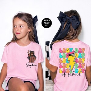 a young girl wearing a pink t-shirt with a cartoon character and the name 'Sophia' printed on it. The t-shirt also has a colorful design with the text "LAST DAY of school" and a lightning bolt.
