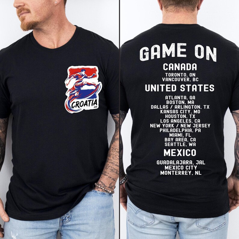 A black t-shirt with text and graphics on the back, including a graphic of a shark and a list of locations.