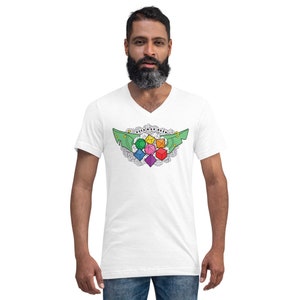 Pode incluir: Camiseta branca de gola em V com um design de asas verdes que apresenta um grupo de dados coloridos no centro. Os dados são cercados por um padrão floral.