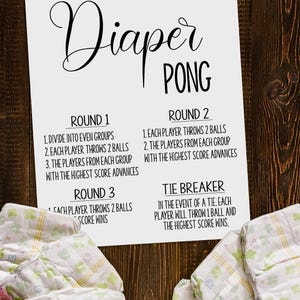Può includere: Un foglio di istruzioni stampabile per un gioco di « diaper pong ». Le istruzioni sono scritte in nero su sfondo bianco. Il testo include le regole di ogni round del gioco, incluso lo spareggio. L'immagine mostra anche due pile di pannolini con un motivo floreale.