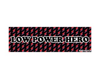 May include: A rectangular sticker with the text "LOW POWER HERO" in white, outlined in black, on a black background with a repeating pattern of red and blue lightning bolts. Small Japanese text is at the bottom.