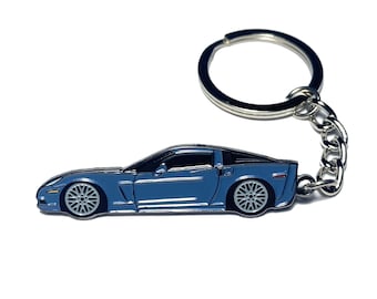 May include: A blue car-shaped keychain with silver accents. The keychain features a detailed car design with silver wheels and a silver chain and ring. The car is a vibrant shade of blue, and the overall design is sleek and modern.