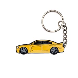 May include: A yellow car-shaped keychain with black accents. The keychain features a detailed design of a car, including wheels and windows. It is attached to a silver chain and keyring.