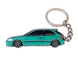 May include: Teal blue car keychain with a silver key ring and chain. The car is a side profile of a compact car with black wheels.
