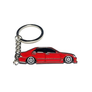 May include: A red metal keychain featuring a detailed silhouette of a car. The keychain has a silver metal ring and chain.