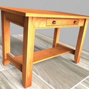 May include: A wooden desk with a single drawer and a lower shelf. The desk is made of light brown wood and has a simple, traditional design.