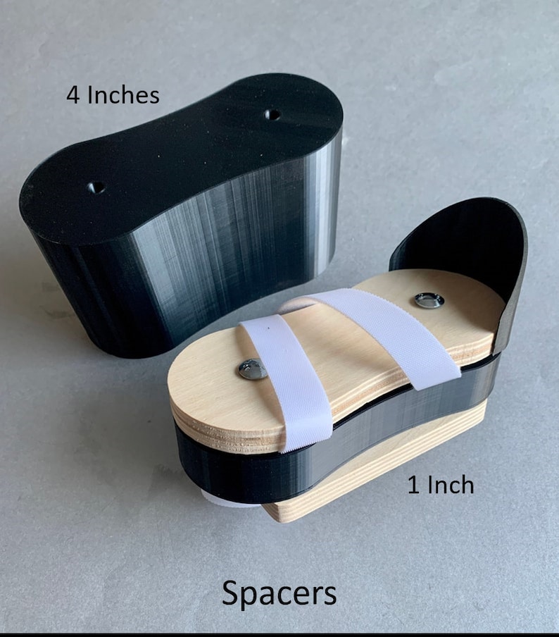 May include: Two black 3D printed spacers, one 4 inches long and the other 1 inch long. The smaller spacer has a wooden platform with white elastic straps. The spacers are labeled "Spacers".