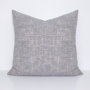 May include: A gray throw pillow with a subtle textured fabric. The pillow is square and has a simple design.