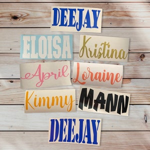 May include: A collection of vinyl decals with names and words in various fonts and colors. The names include "DEEJAY", "ELOISA", "Kristina", "April", "Loraine", "Kimmy", and "MANN". The decals are in blue, gold, pink, orange, and black.