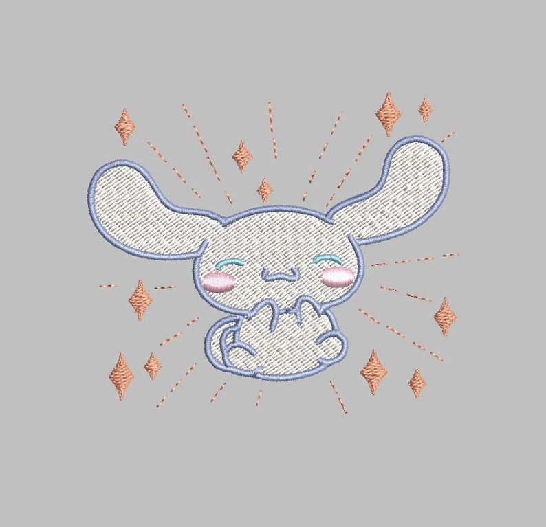May include: A white embroidered cartoon character with blue eyes and pink cheeks. The character is surrounded by a burst of orange stars.
