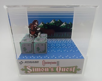 May include: A clear acrylic display case with a pixelated 8-bit video game character from Castlevania II: Simon's Quest. The character is standing on a platform with a blue and white background.