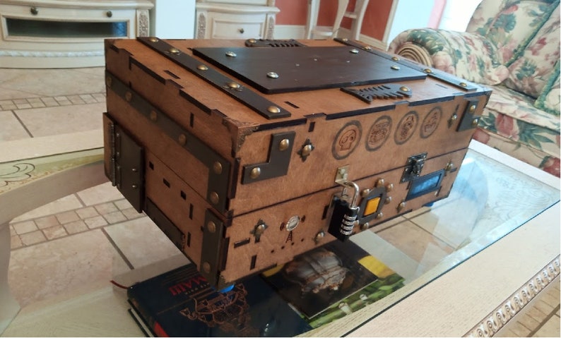 Puede incluir: Un cofre del tesoro de madera con detalles met&aacute;licos y una cerradura de combinaci&oacute;n. El cofre tiene un tinte marr&oacute;n y una tapa de cuero marr&oacute;n oscuro. Hay varios s&iacute;mbolos tallados en la parte delantera del cofre.